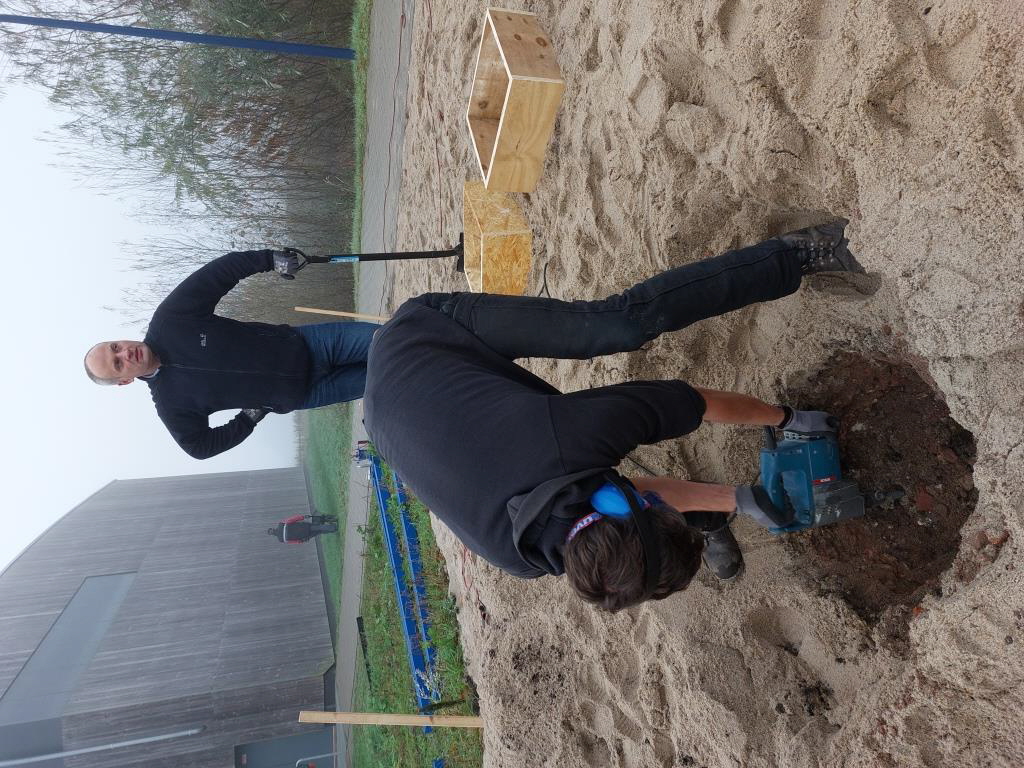 Der obere Sand war schnell zu Seite geräumt, aber dann war es plötzlich etwas hart. 25 cm verdicheter Schotter versperrte uns den Weg. Zum Glück hatte Roman einen Bohrhammer geholt und so musste er jedes der 4 Löcher durchbohren.